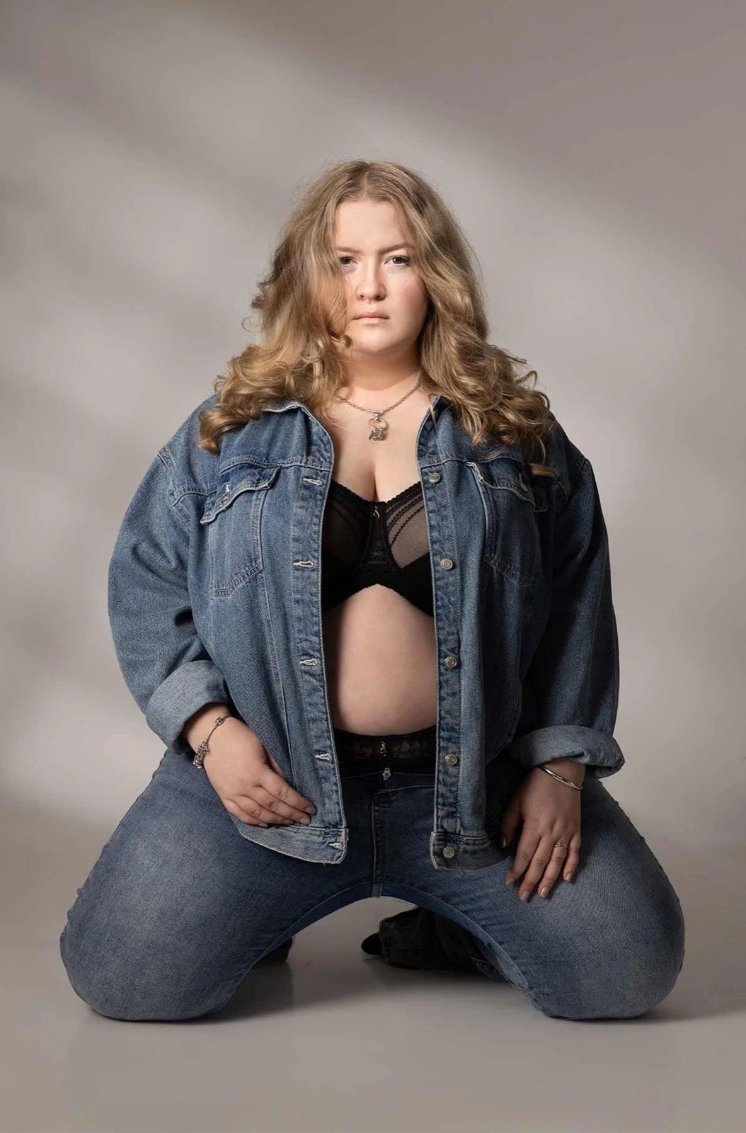 Confident boudoir portrait wearing an oversized denim jacket